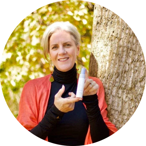 Ellie Whalen, founder of Sprayology, holding a Sprayology spray bottle outdoors