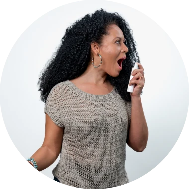 A woman using a Sprayology oral spray